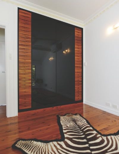 Built In Wardrobes with Cypress Pine Slats and Black Glass Panels Sliding Doors