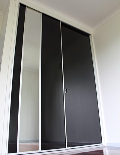 Polished Timber Floorboards, Black Glass Sliding Doors with insert mirror