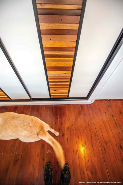 Hallway Sliding cupboard Doors with Jarrah and cypress pine timber slats.  That match the floor and the red heeler dog