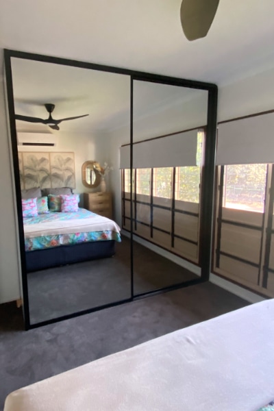 Elegant mirror sliding wardrobe doors with chic black glass frames, demonstrating custom-fit up to 2700mm high, perfect for any room, reflecting Darwin's local expertise in creating durable and stylish wardrobes.