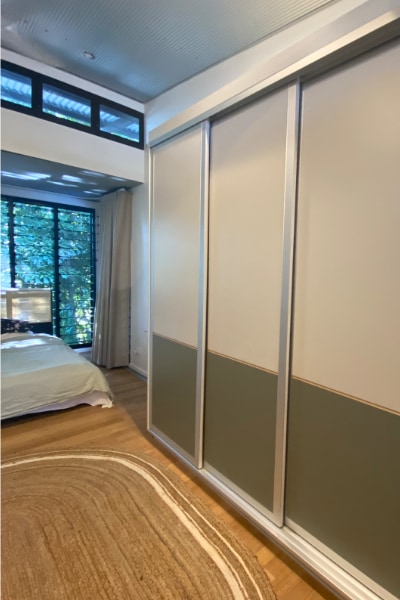 Sliding doors with top panel in Topiary Green Smooth and lower panel in Verdelho Smooth, featuring a timber veneer V Groove detail.